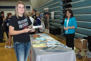 Kirsten Elstad takes advantage of the brochures and pamphlets offered at the college fair