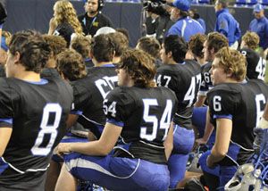 Huskies football team kneeling in respect for their injured teammate 