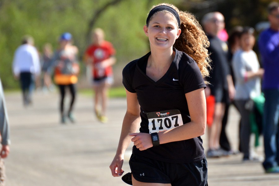 Zoe Kienholz smiles as her friends cheer her on. She placed second in the half marathon in her age group, being beaten by Elena Bueltel