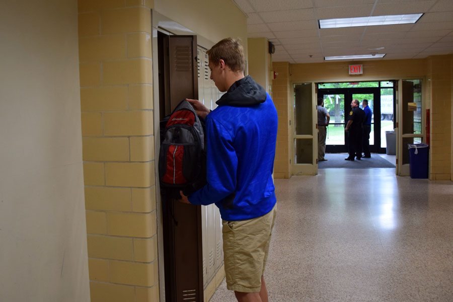 Freshman David Crawford puts belongings in locker. Staff secure doors to Harriet Street