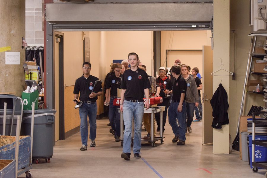 Team 4624 drive team bring the robot to queue for their next match
