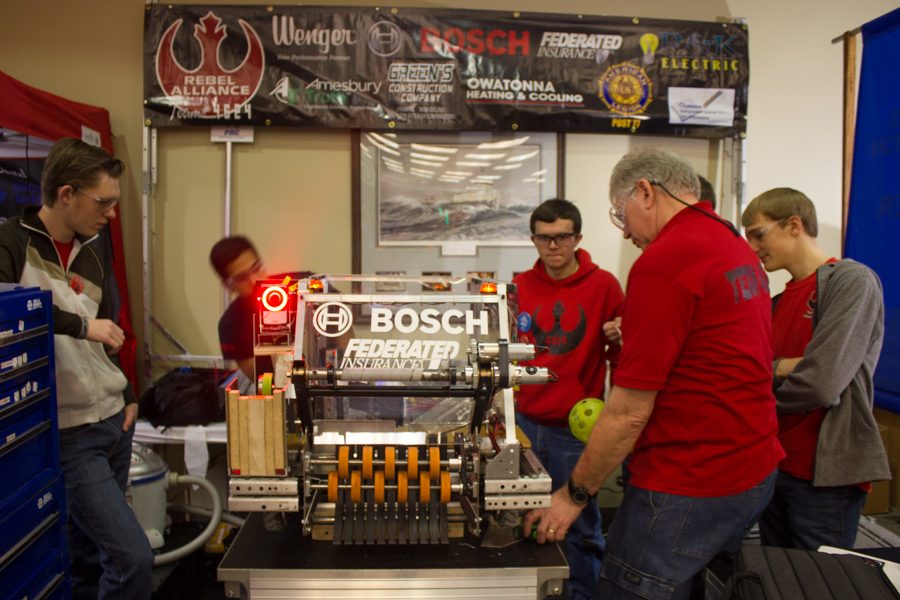 Drive team members make final adjustments to the robot before the match in the pits.