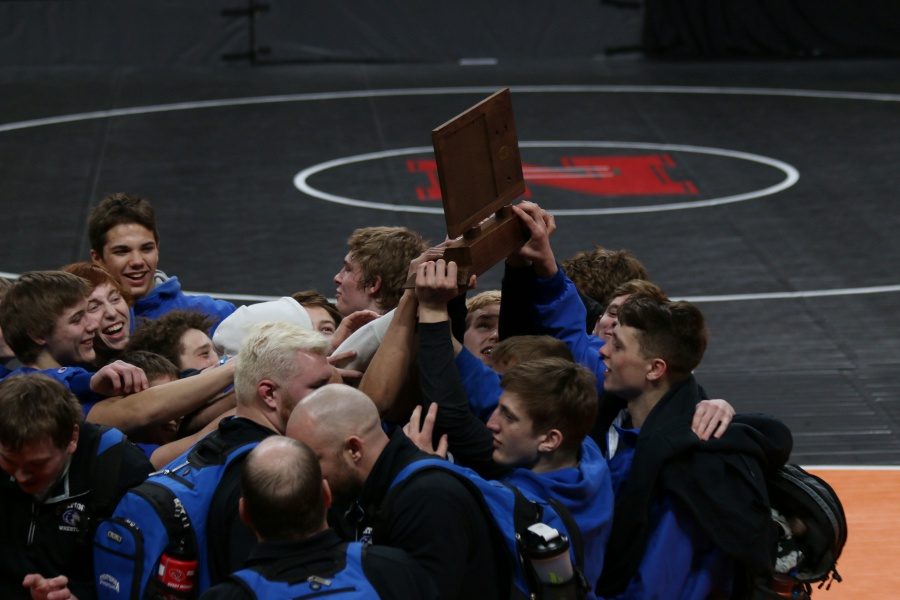 OHS Wrestlers hold up the Consolation trophy in celebration at the Excel Energy Center