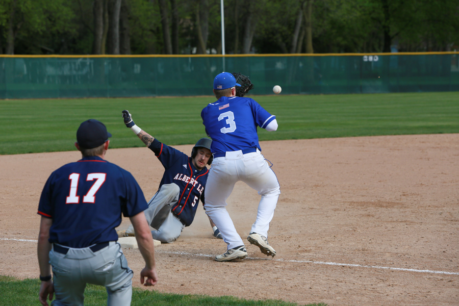 Abe Havelka Tries to make an out at third base as the runner slides in safe.