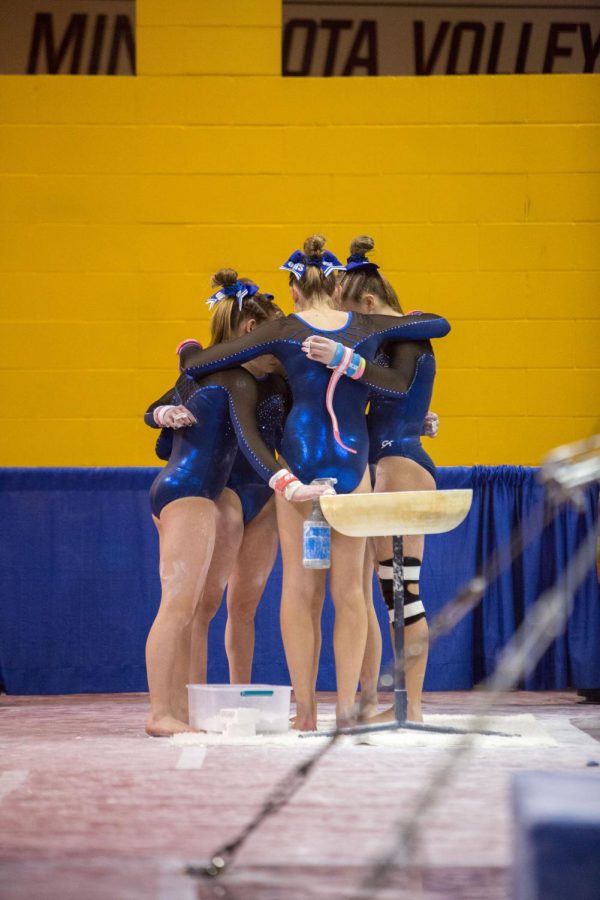 Before their first event (the uneven bars) the team huddles