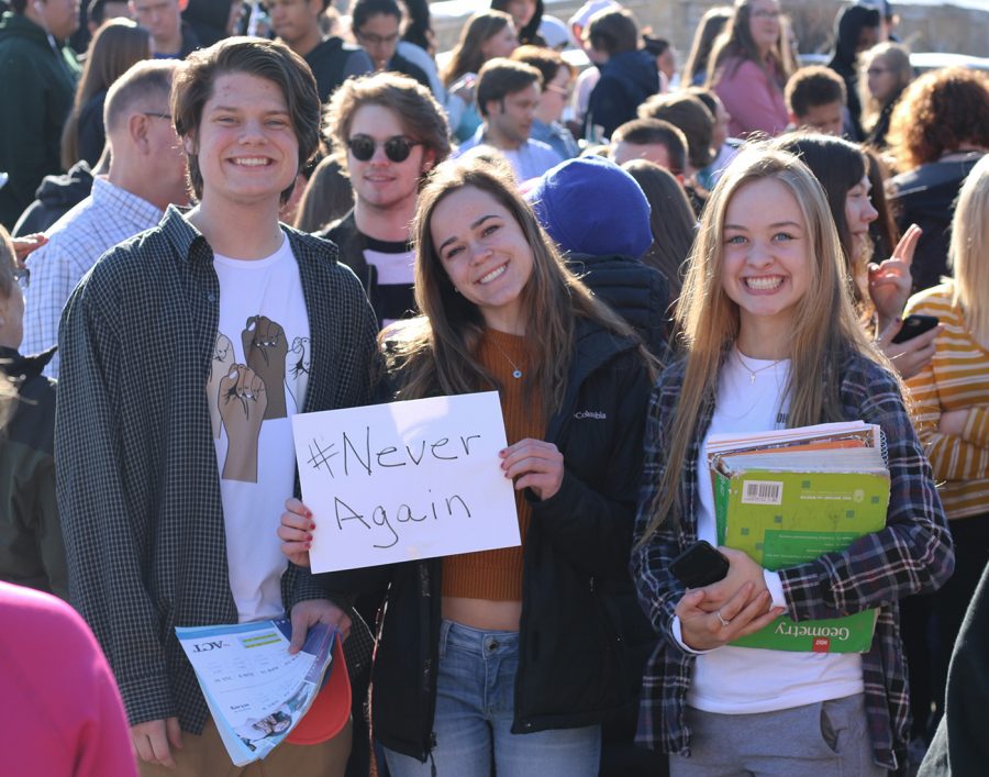 Noah Wagner, McKenzie Haberman and Cecilia Nicholson pose with a poster supporting #NeverAgain