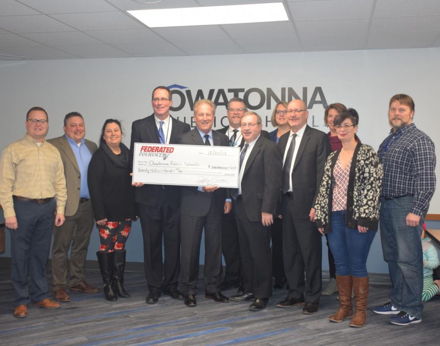 CEO Jeff Fetters and CFO Mike Keller present the check from Federated Insurance to the Owatonna School Board at 7 a.m. on Dec. 20, 2019