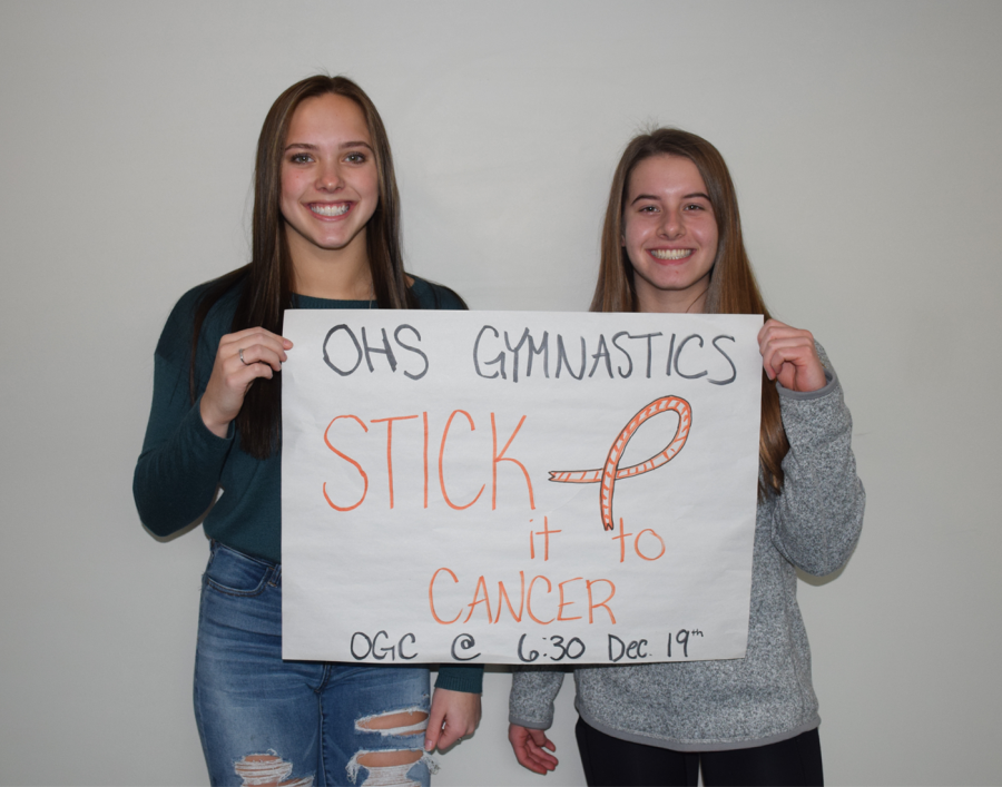 Lindsay Bangs and Lucy Macius holding a stick it to cancer sign.