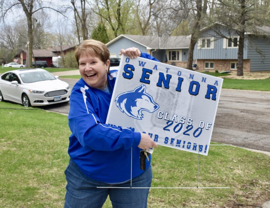 Ms. Lage holding up the senior yard sign