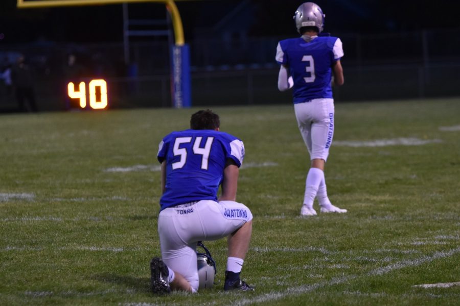Senior+Abe+Stockwell+takes+a+knee+to+pray+before+the+game+begins.