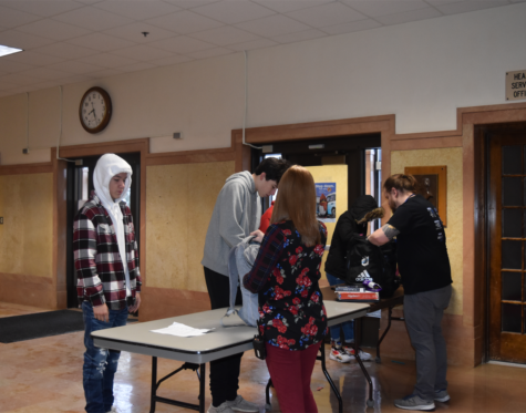OHS students get their backpacks checked by the main doors