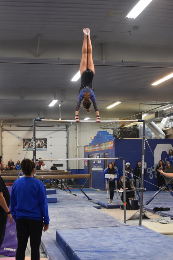 Sophomore Emma Johnson ready to complete her bar routine with a giant to layout dismount.