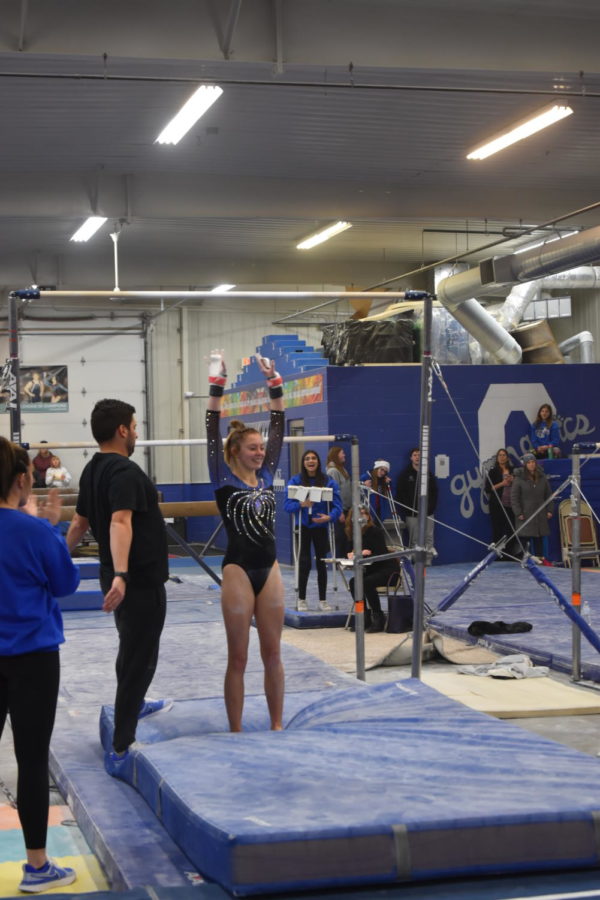 Freshman Jozie Johnson finishes her bar routine with a stuck layout full dismount.