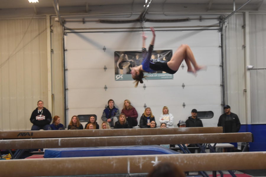 Freshman Jozie Johnson completes a back tuck on the four inch wide balance beam.