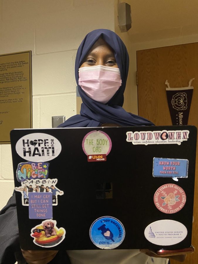 Senior Fardouza Farah highlights her participation and activism advocating for things she's passionate about with a collage of stickers on her laptop.