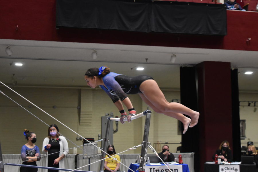 Senior Janessa Moore doing a stoop to the high bar during her final bar routine.