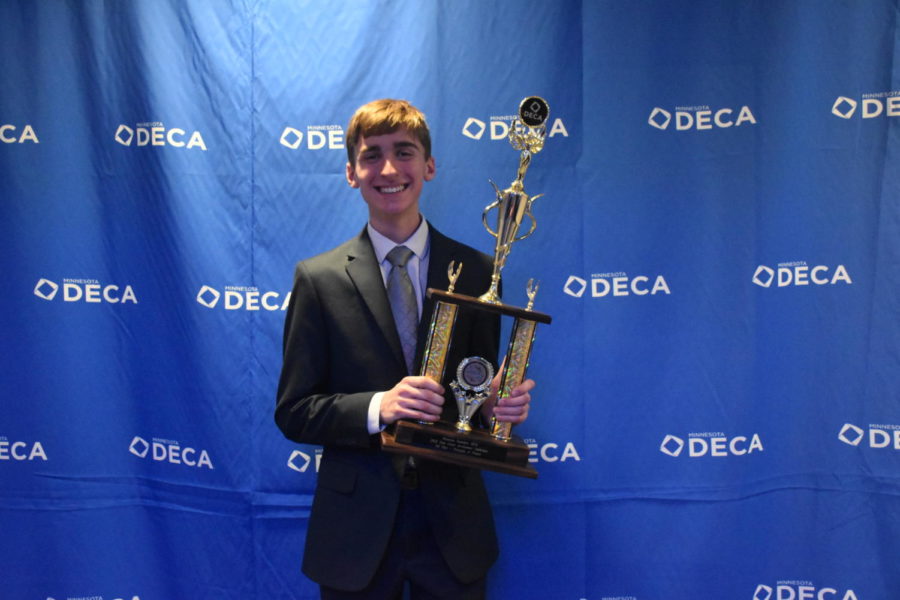 Senior Dylan Meiners holds up his trophy after winning fourth place in Principles of Finance at DECA State. 