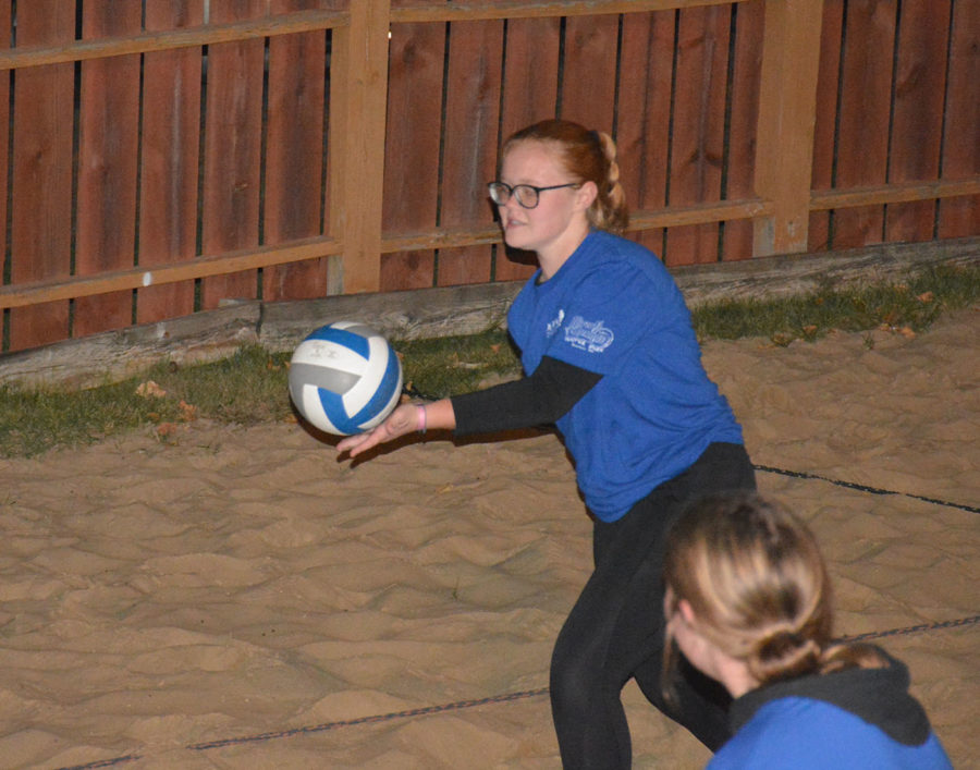 Madelyn Fisher serving the ball into play during the sand volleyball tournament.  