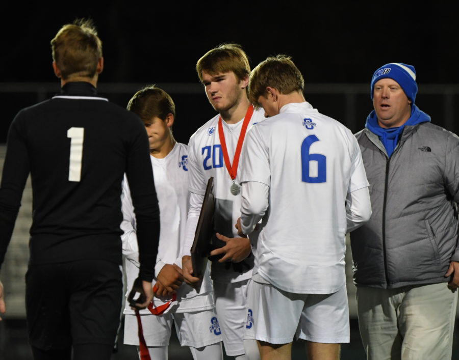 A HEARTBREAKING LOSS. Boys soccer captains receive their second-place plaque from Marc Achterkirch after their loss against Rochester Mayo.