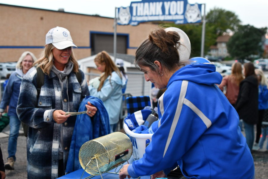 Owatonna Huskies fan pays for raffle ticket at the annual homecoming game.