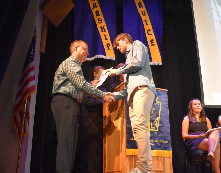 Senior Ty Svenby shaking Mr. Kaths hand after signing the NHS book.