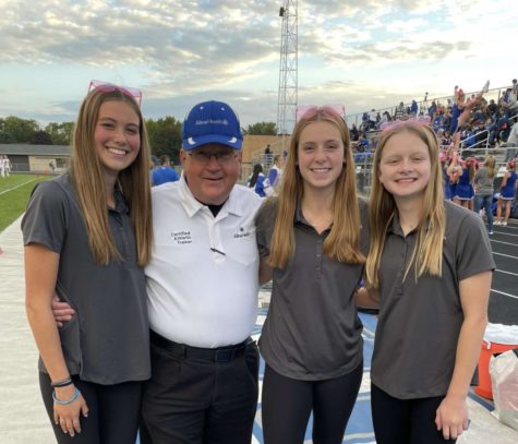 Mr. Carlyle poses with three of his 2022-23 student trainers.