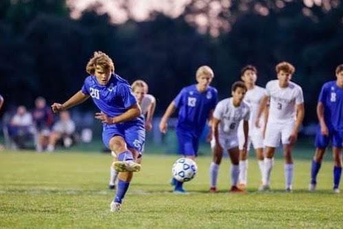 First Team All-State striker Benny Bangs kicks the ball at the net.
