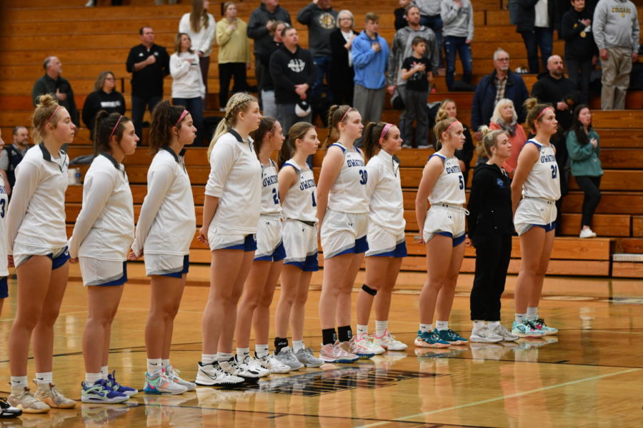 The Owatonna Girls basketball team lines up for the National Anthem