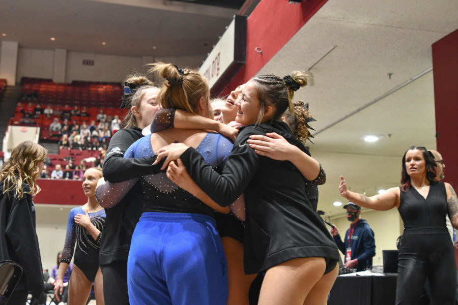 The OHS Gymnastics team celebrating after all five Huskies stuck their beam routines.