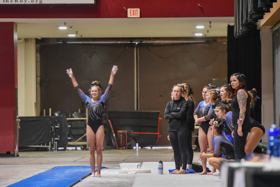 Jozie Johnson saluting to the judges before anchoring the Huskies vault lineup.