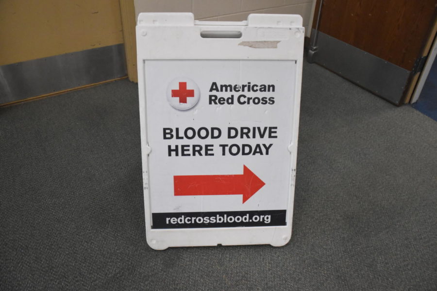 The American Red Cross sign guiding people to where the site to donate blood is. 