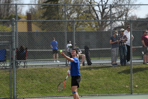 Junior Thomas Herzog tossing the ball to serve to his opponent.