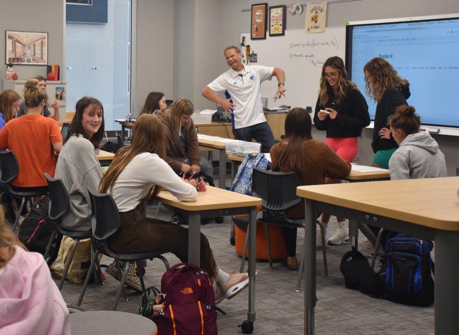Mr. Leer poses for a photo while teaching his yearbook class. 
