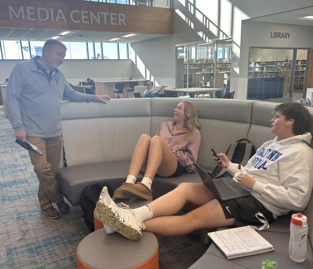 Dean of students Doug Wanous reminds students Makenna Neumann and Calden Durand to stay off their phones during class time. 