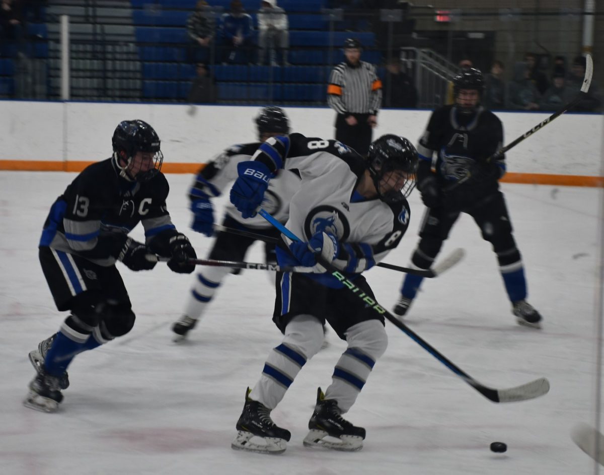 Senior Justin Beman protects the puck as he carries it into the zone. 