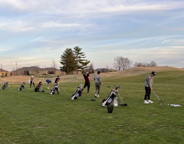 Boys Golf team warming up at the driving range before a meet.