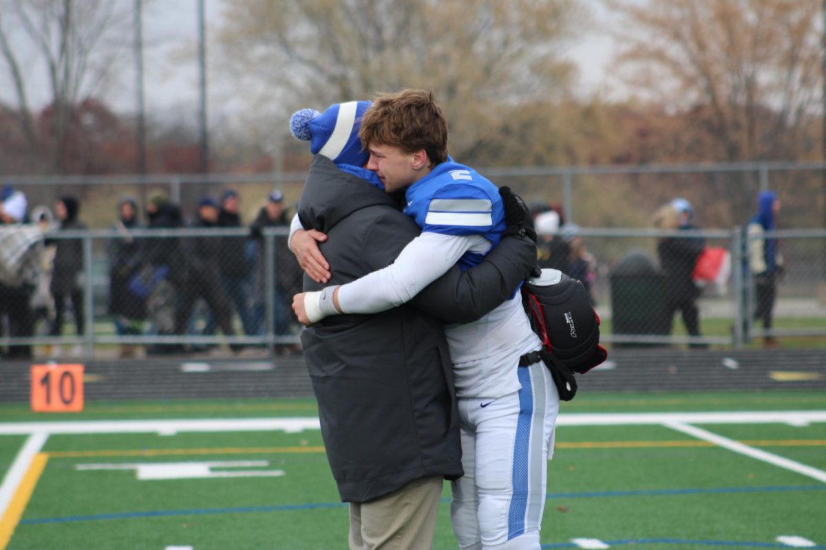 Senior+Jacob+Ginskey+hugs+a+coach+after+his+final+football+game+at+Quarterback+for+the+Huskies.