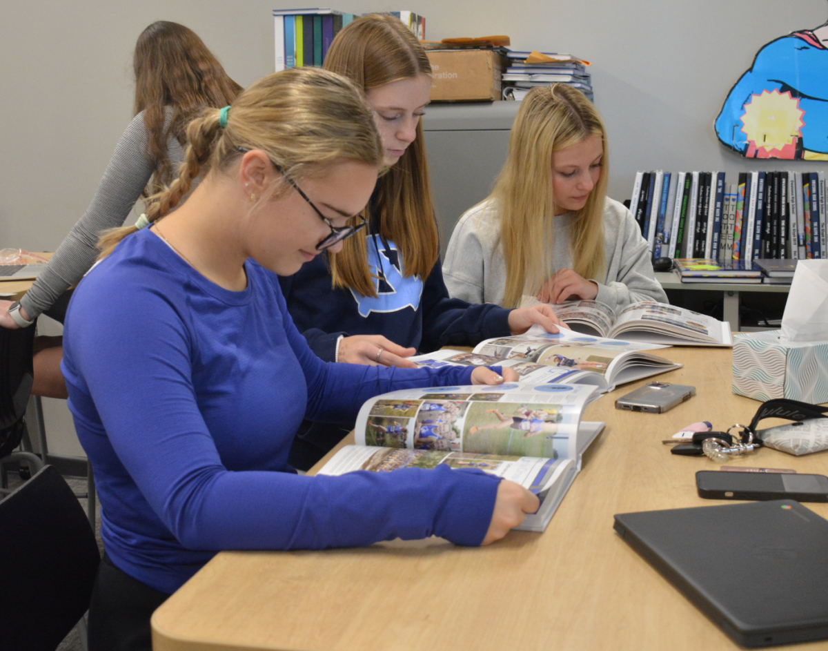 Yearbook staff looks over the final print after the yearbooks come in.