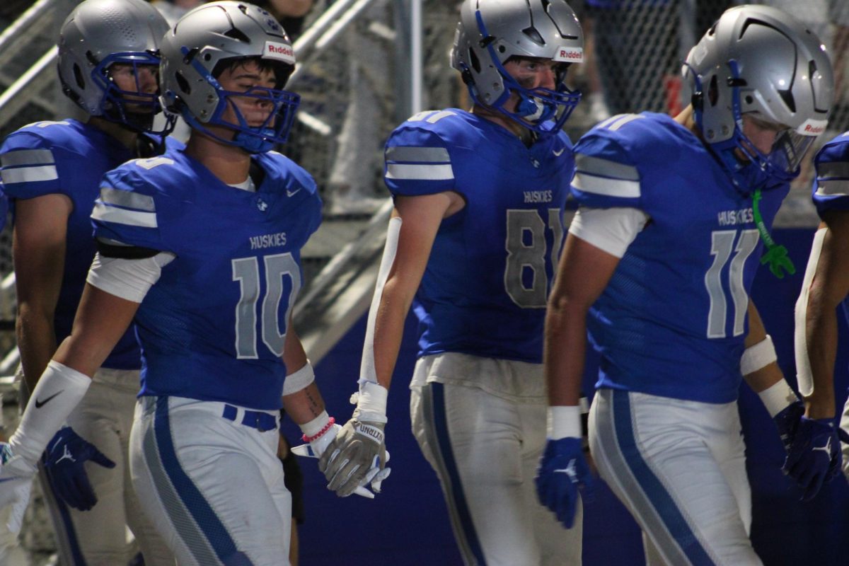 Seniors Black Fitcher and Zach Haarstad hold hands as they make their way back on the field.