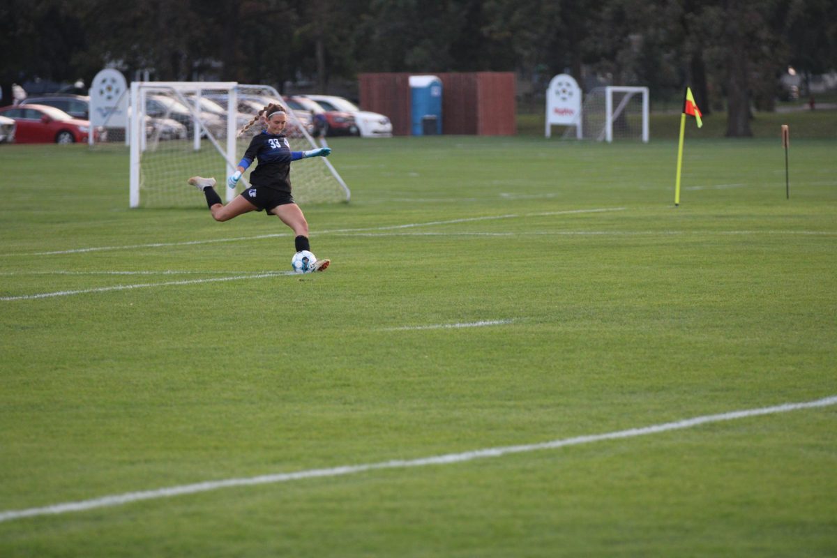 Senior goalie Anna Mollenhauer kicks the ball back into the game.