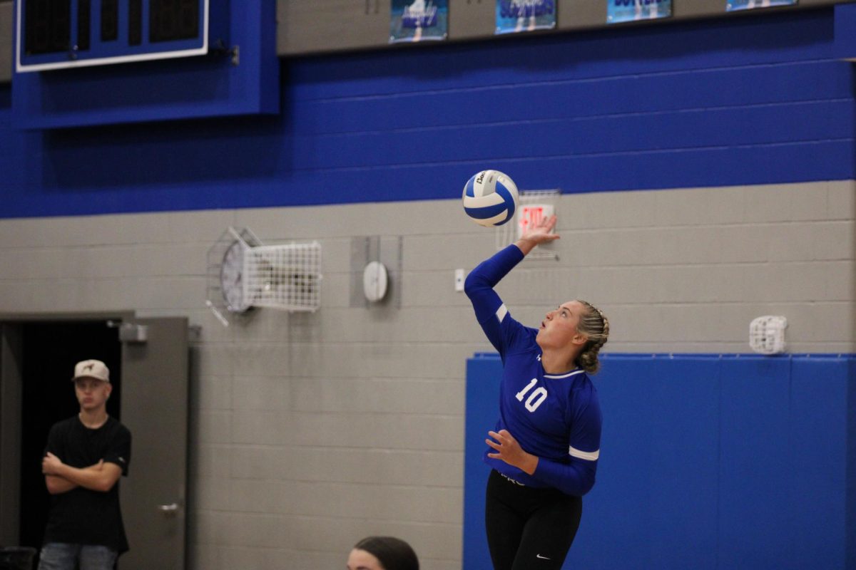 Junior Addy Schroht jumping to set the ball after scoring. 