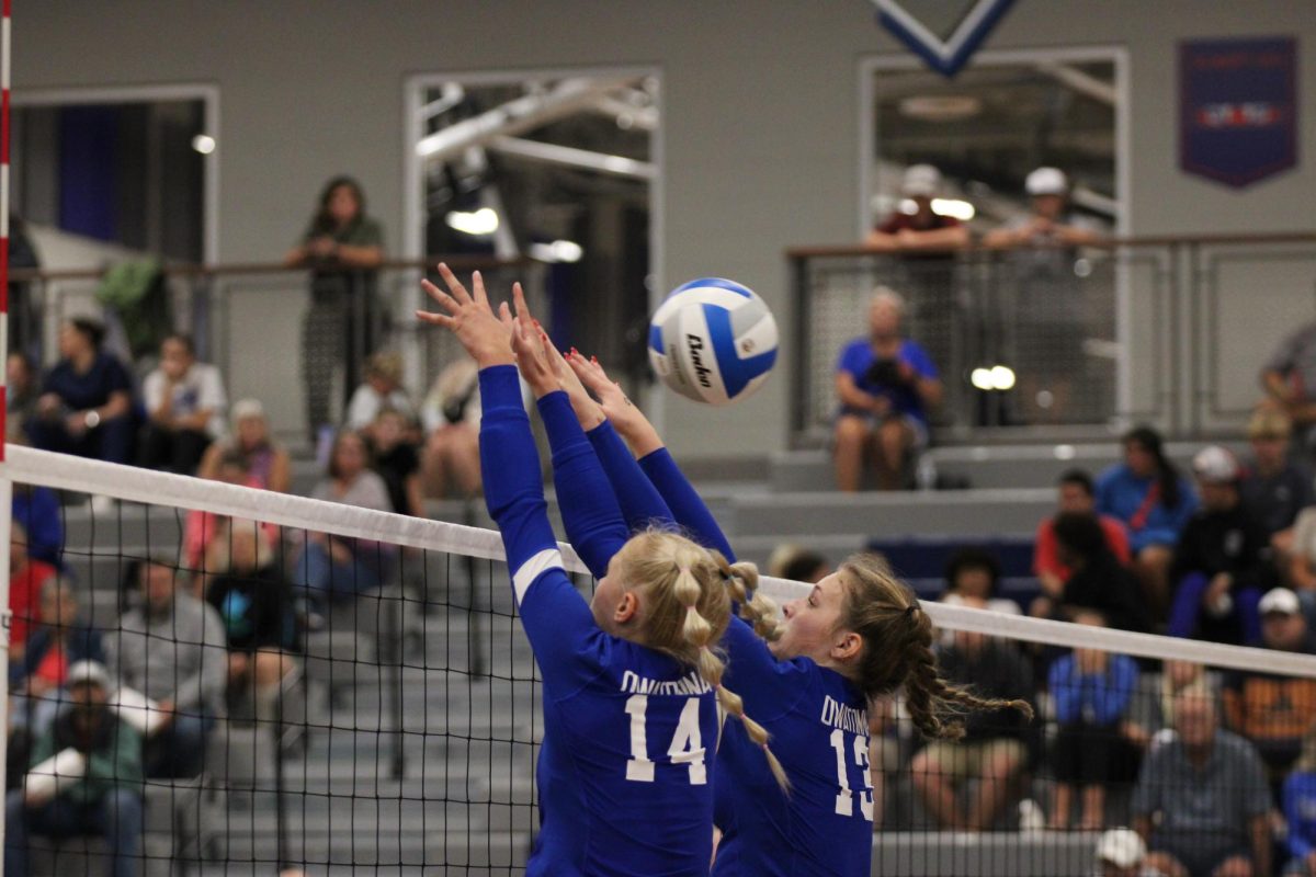 Junior Kendra Bogen (#14) and Danielle Roush (#13) attempt to block a spike.