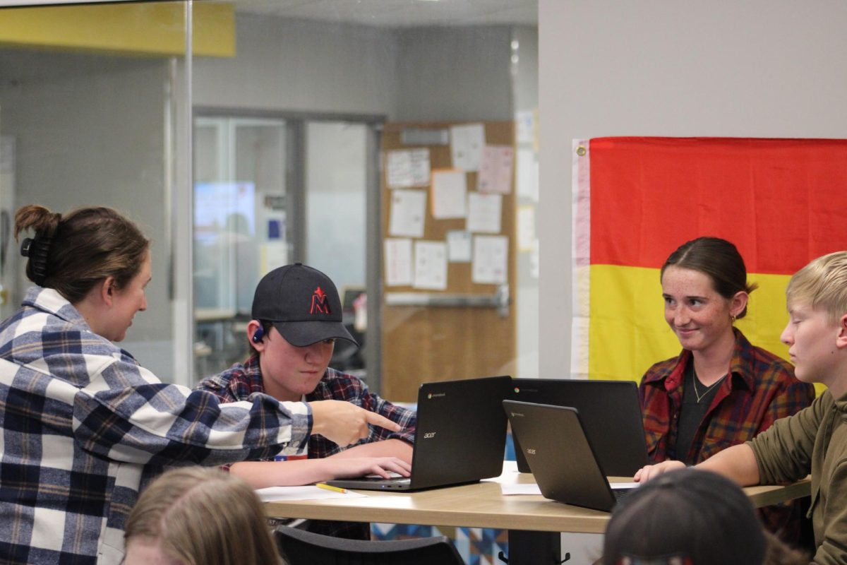 Ms. Truatman teaches a group of kids Spanish. Sophomore Amelie Tolle smiles along. 