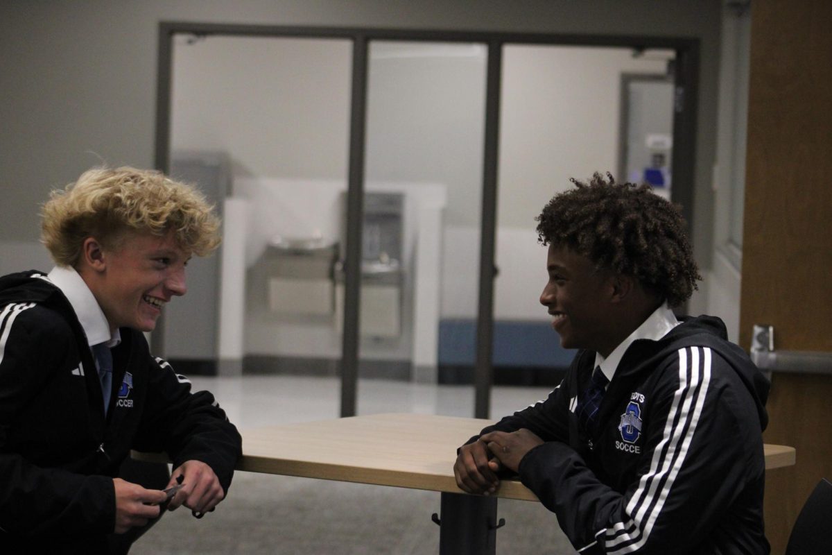 Freshman Logan Wilker and sophomore Akram Haji laugh in the halls.