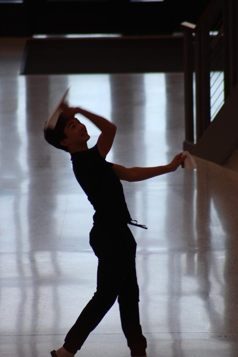 Sophomore Jacob Wilson throws a paper airplane to the second floor. 