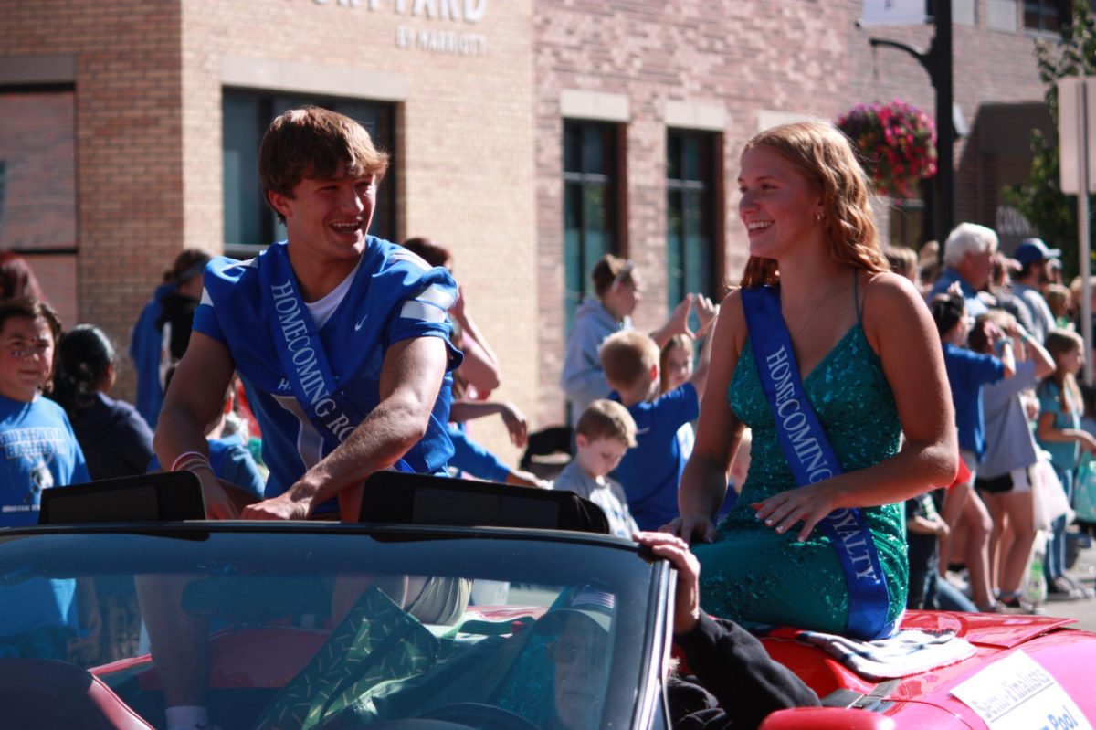 Senior Luke Webber and Senior Maryn Pool laugh and smile during the parade.