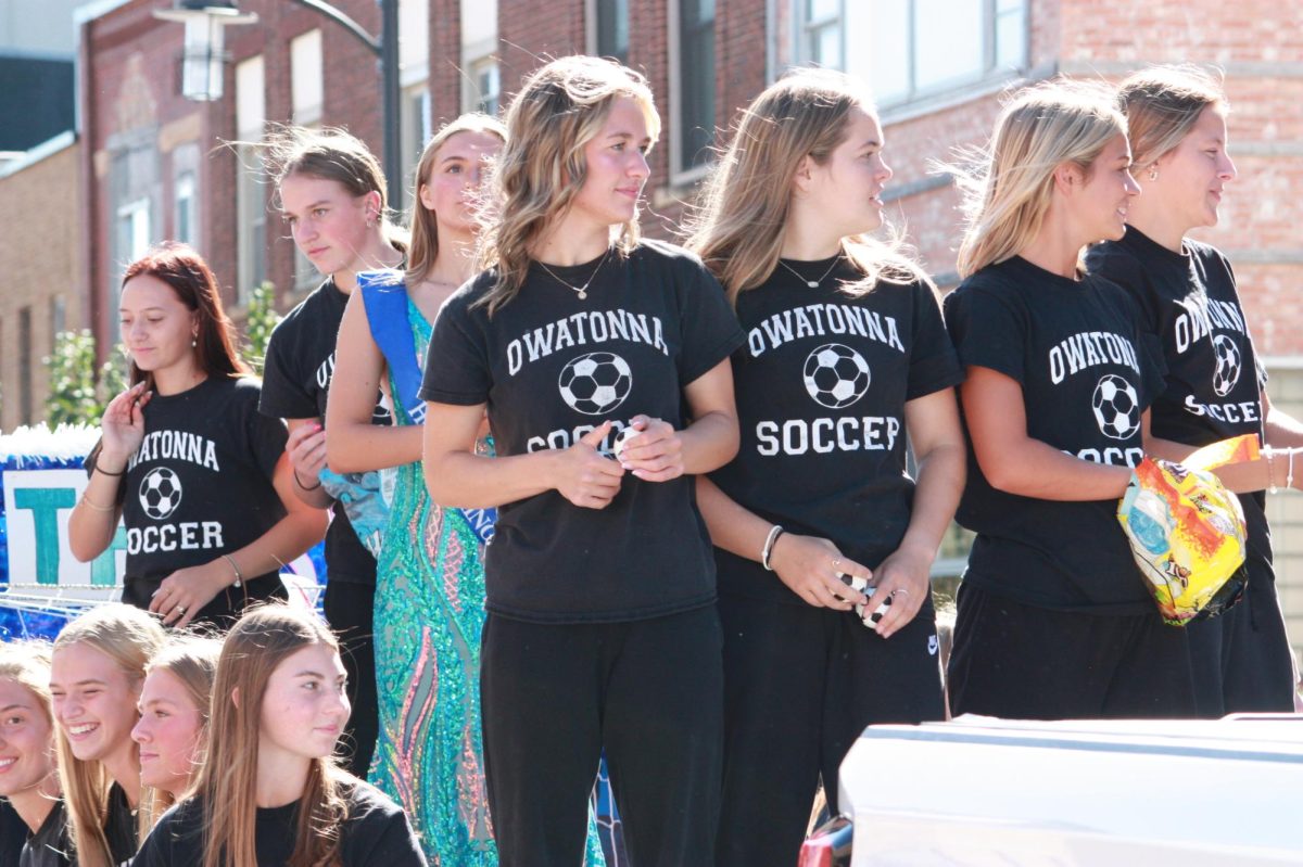 Owatonna Girls Soccer team throw out candy and mini soccer balls throughout the parade.