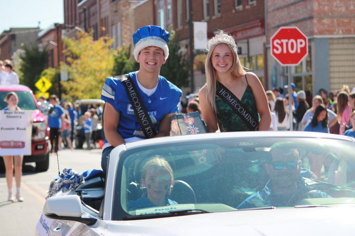 Senior Nolan Ginsky and Senior Aza Lewis smile through the parade as king and queen.