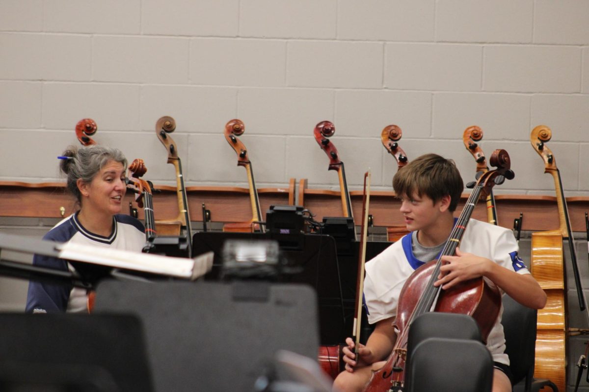 Joash Packard practices with Ms. Justice in orchestra room.  