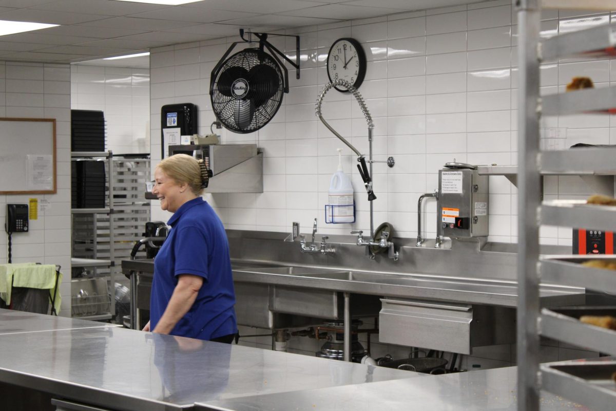 An OHS lunch lady politely laughs to herself as she re-enters the kitchen.  
